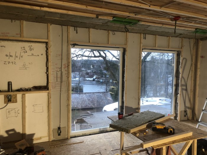 Nytt installerade fönster i en renoveringsmiljö med byggnadsmaterial och verktyg.