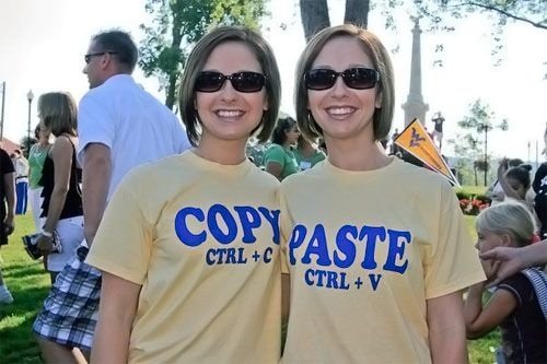 Tvillingar i matchande 'Copy CTRL + C' och 'Paste CTRL + V' t-shirts.