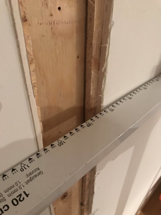 Detaljbild på gips och plywood i hörn där skivorna inte är jämnt monterade, med synlig avvikelse.