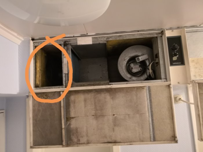 Öppet ventilationssystem med synligt rör och damm, omringat av ett orangetejpat område.