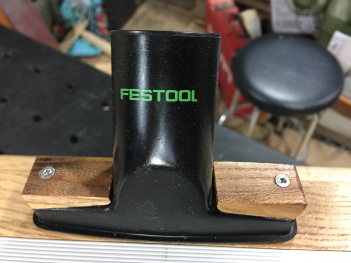 Svart plastanordning märkt "FESTOOL" fäst på träyta med skruvar, en del av hemmagjord fräsinsats.