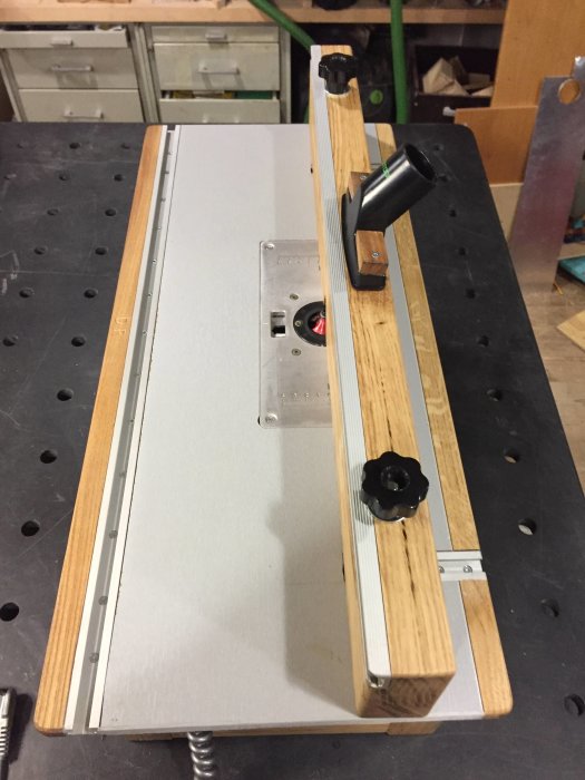 Custom-built router table insert for "Gåbortsågen" with a wooden fence and modified clamp.