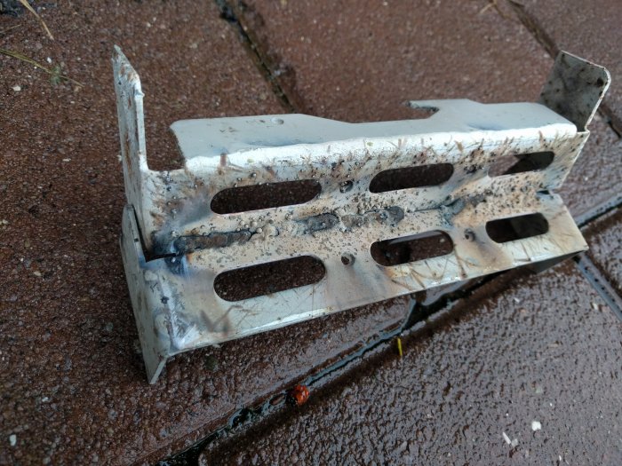 Svetsförsök på två metallbitar med synliga svetsar och bränning, utfört med billig svetsutrustning.