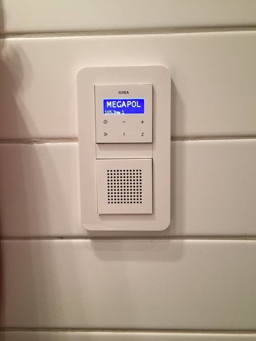 Inbyggd väggradio GIRA med skärm visar radiostationen MEGAPOL och kontrollknappar.