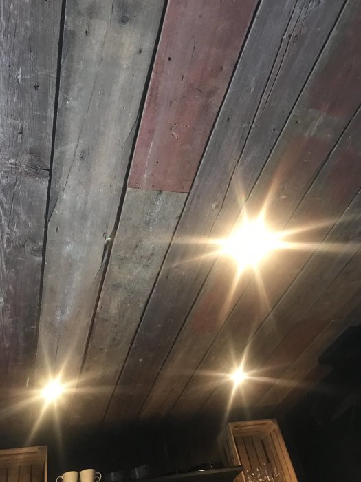 Renoverat kök med träpanel i taket och infällda spotlights som lyser upp rummet.