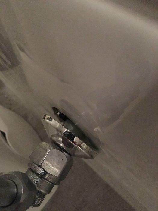 Detaljbild av en icke-estetisk rörinstallation med synlig mutter och utan kromad fördelare i ett badrum.