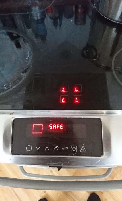 Electrolux EKC70751X spishäll visar låsta kokzoner med röda "L" symboler och ett "SAFE" meddelande.
