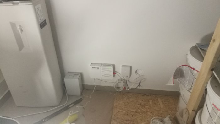 Installerad fiberanslutningsutrustning med router och kablar i ett hörn av ett rum.