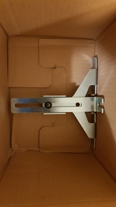 Metallfräs i profil placerad inuti en brun kartong.