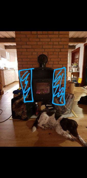 Kamin med markerade platser för tankar, hund framför, vedkorgar och träheminteriör.