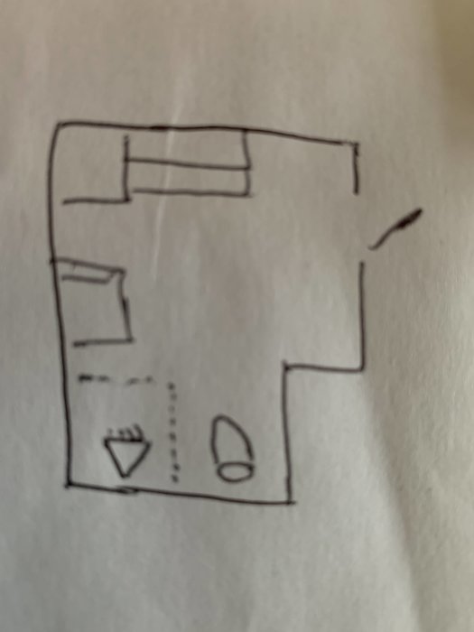 Handritad skiss av ett rums layout med möbler och sanitetsobjekt.