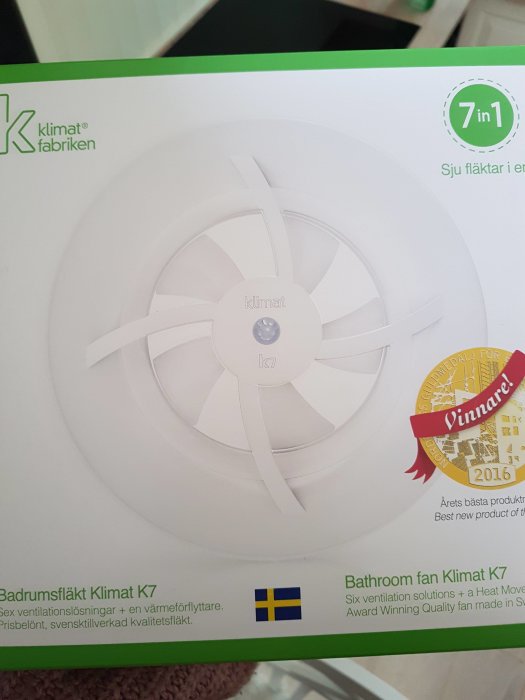 Förpackning av Badrumsfläkt Klimat K7 med "7 i 1"-funktioner och svensk flagga, "Årets produkt"-utmärkelse.