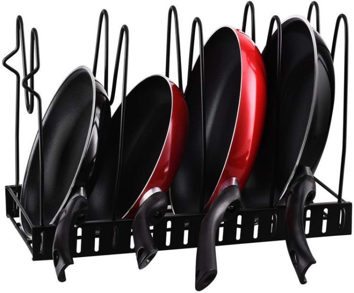 Stekpannor i olika storlekar förvarade i en ställning med svarta och röda färger.