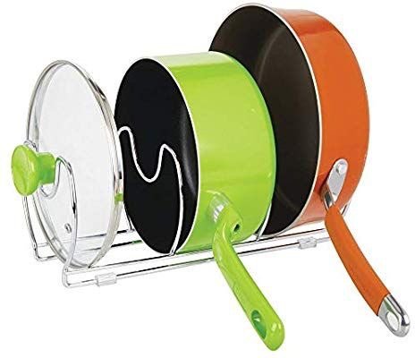 Färgglada kastruller med lock och grönt handtag på ställning.