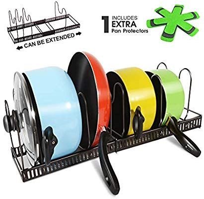 Färgglada kastruller med svarta handtag på ett justerbart kastrullställ.