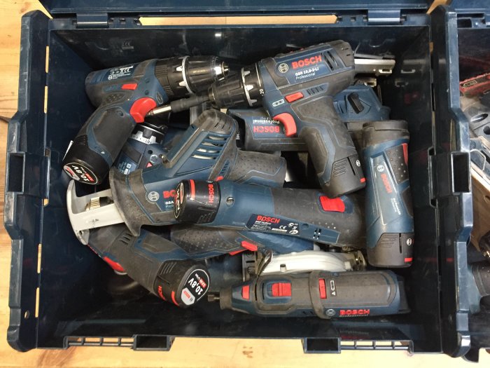 Öppen verktygslåda fylld med olika Bosch batterimaskiner utan ordning.