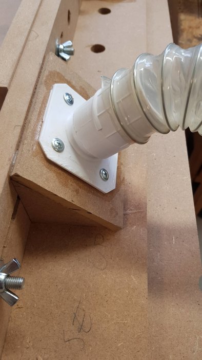 3D-utskrivet sugslangsinterface i hobbyverkstad kopplat till transparent slang.