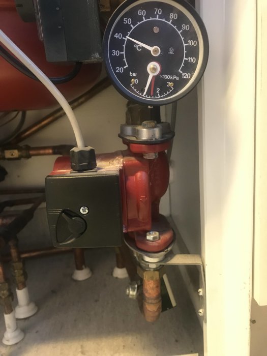 Värmesystem med RVP32, manometer visar lågt tryck, röda rör och pump, tickande ljud.