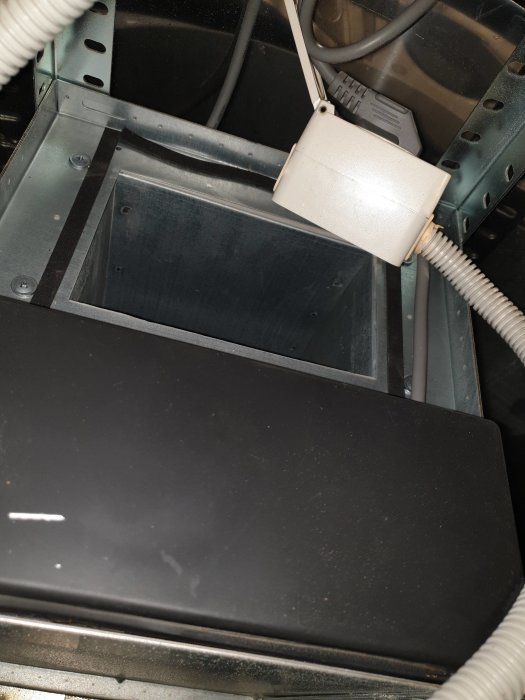 Toppvy inne i en spiskåpa visar elektriska anslutningar och öppning för ventilation.