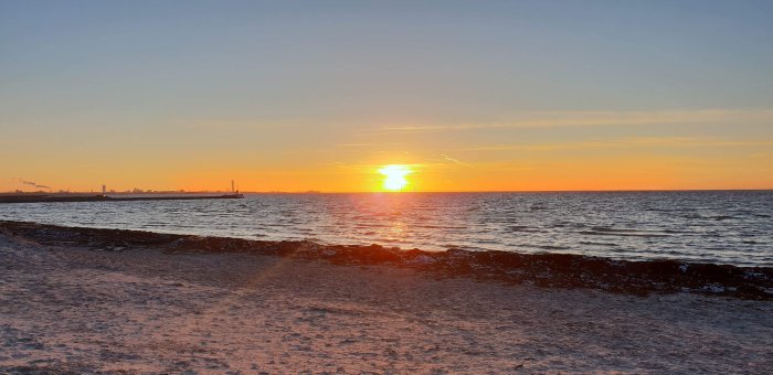 Solnedgång över havet sett från stranden under en joggingrunda.