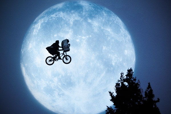 Silhuett av en cyklist och E.T. framför en fullmåne som liknar scenen från filmen E.T.
