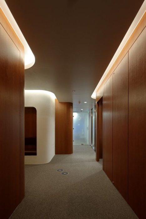 Korridor med släta, lyxiga teak-liknande träväggar och integrerad belysning i taket.