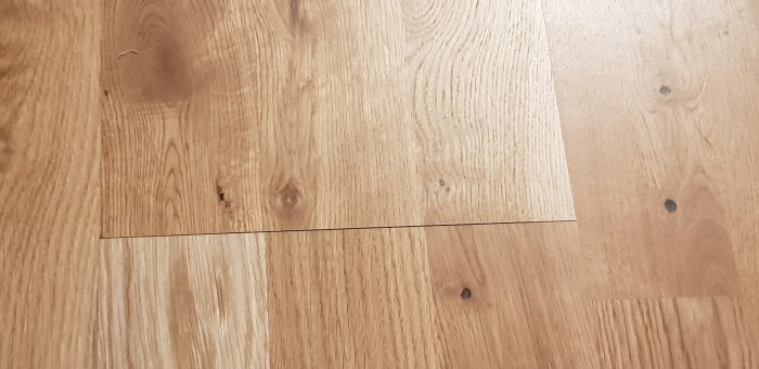 Trägolv med synliga skarvar mellan plankorna, tecken på ojämn installation.