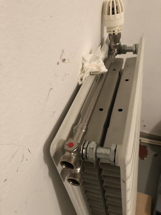 En radiator med anslutningar för omställning från 1-rörs till 2-rörs system, övre och nedersta anslutningen synlig.