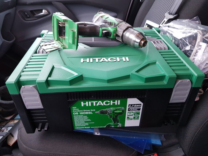 Ny Hitachi DS 18 DBSL borrskruvdragare i bilen, i grön förvaringslåda med logotyp och extra batterier.