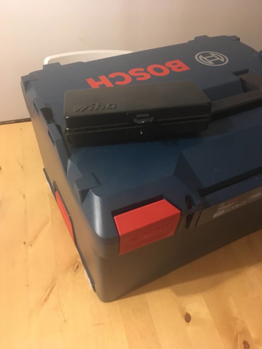 Bosch verktygslåda ovanpå Wiha microbit sats, båda på trägolv.