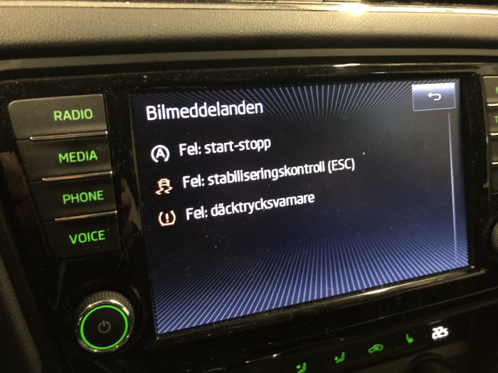 Bild av bilens infotainmentskärm som visar felmeddelanden: start-stopp, stabiliseringskontroll (ESC), däcktryck.