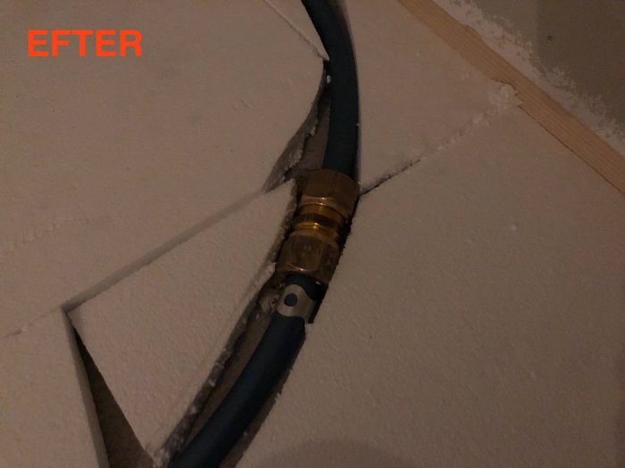 Skarvning av golvvärmerör i en klädkammare, omgiven av osammanhängande isolering och texten "EFTER" synlig.