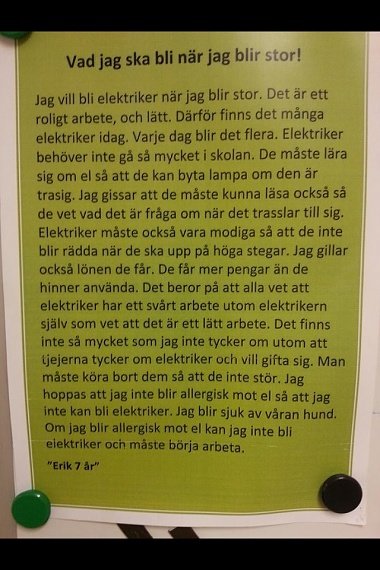 Handskriven text på ett uppslaget papper med rubriken "Vad jag ska bli när jag blir stor", skriven av Erik 7 år, om att vilja bli elektriker.