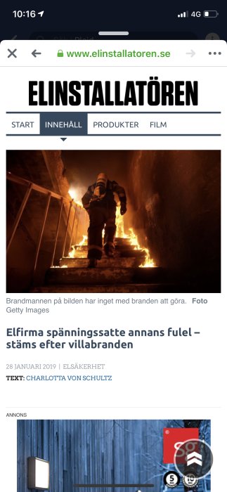 Brandman i full utrustning går nerför en trappa i en byggnad som står i lågor.