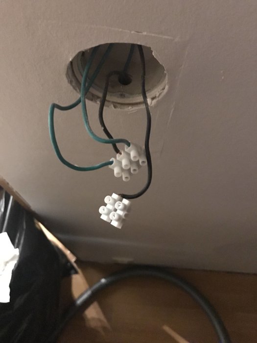 Elektriska sladdar med skarvklämmor sticker ut ur en vägg, okopplade och redo för installation.