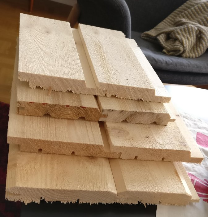 Obehandlad träpanel placerad i en stapel med synliga sågade kanter och träets ådring.