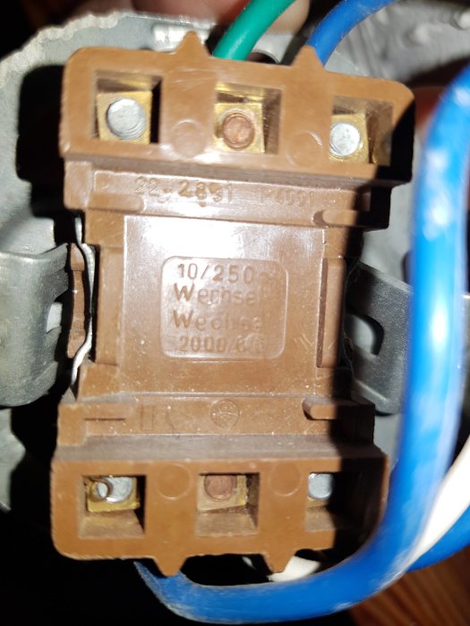 Baksidan av en eluttag med skruvanslutningar och elektriska ledningar.