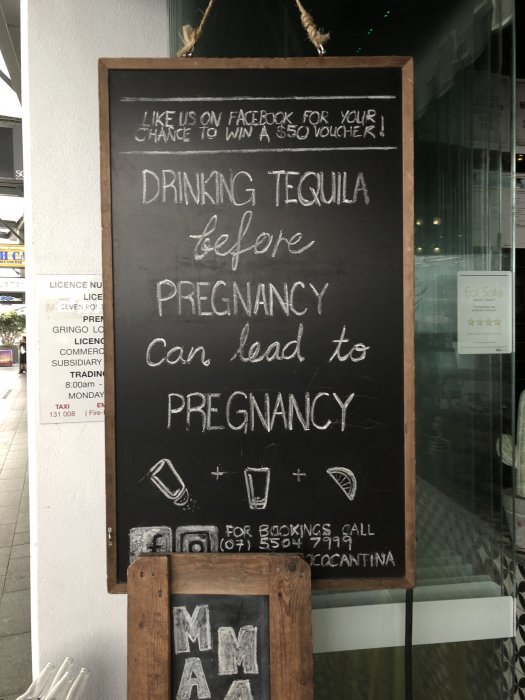 Svart skylt med krittext: "DRINKING TEQUILA before PREGNANCY can lead to PREGNANCY", rita glas, kampanj för Facebook-gilla och kontaktinfo.