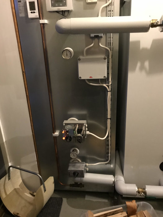 Värmepannans system med två elpatroner anslutna till en ackumulatortank, termostater och kopparledningar.