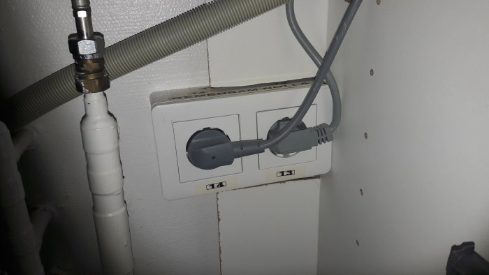 Eluttag märkta "14" och "13" med en inkopplad kabel och texten "OBS Gemensam nolla" ovanför.