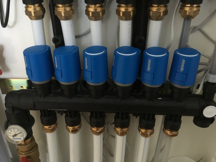 Uponor Smartix Wave golvvärmesystems styrdon med fördelare och rör.