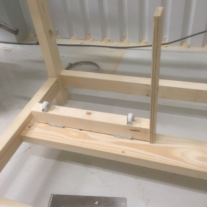 Del av träracket i en byggkonstruktion med en synlig sågspårslist mellan två trädelar.