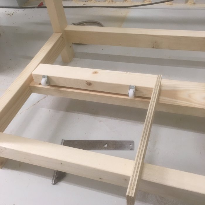 Delvis påbyggt träställningsprojekt med synlig sågspårslist och metallfästen.