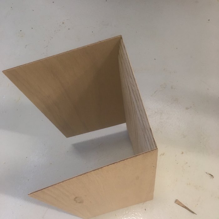 Träkonstruktion av början till en cyklonspåntratt med fasade kanter och oregelbundna vinklar.