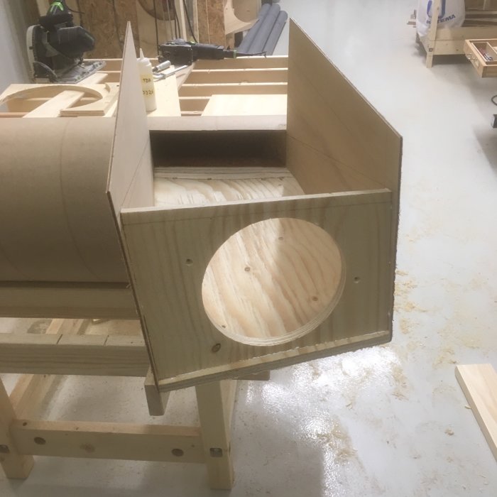 Konstruktion av en träspåntratt för cyklon med fasade kanter och en rund öppning, placerad i ett snickeri.