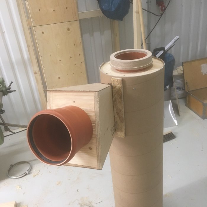 Hemmagjord träspåntratt i början av konstruktion, ihopsatt med träbitar och ett terrakottarör.