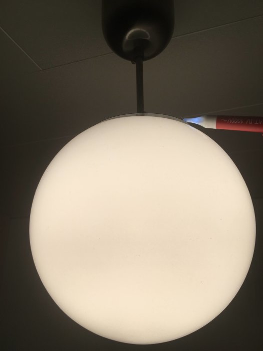 Oupphängd taklampa tänd med synlig strömförande kabel och ojordad armatur.