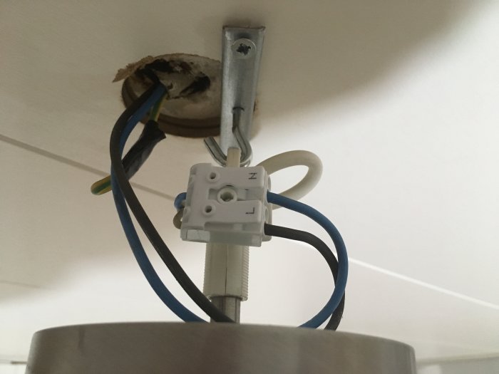 Installationsvy av en taklampa med synliga elektriska anslutningar och kablar utan synlig jordning.