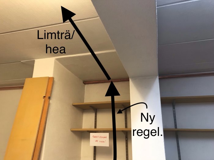 Inomhusvy med två takbjälkar och en handskriven lapp som föreslår placering av ny limträ- eller HEA-balk för stöd.