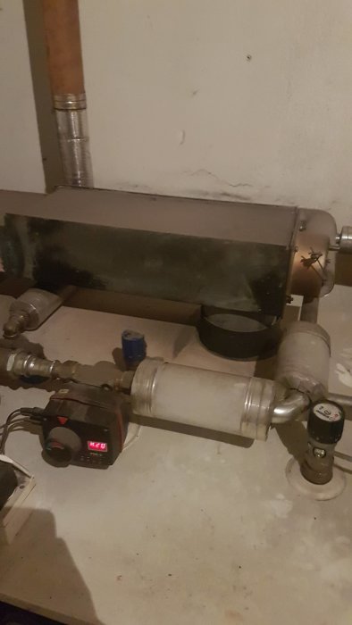 Ackumulatortank och pump i ett pannrum som en del av ett värmesystem.